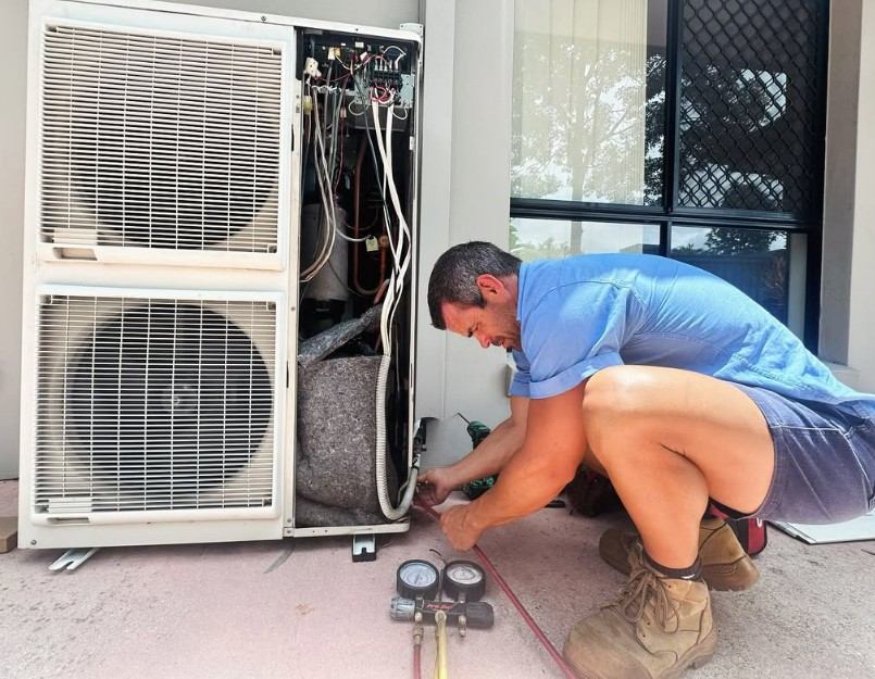 Brad repairing an outdoors AC unit