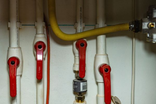a set of white pipes with red valves for central heating