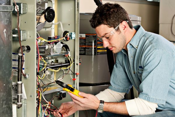 a technician testing things during furnace replacement
