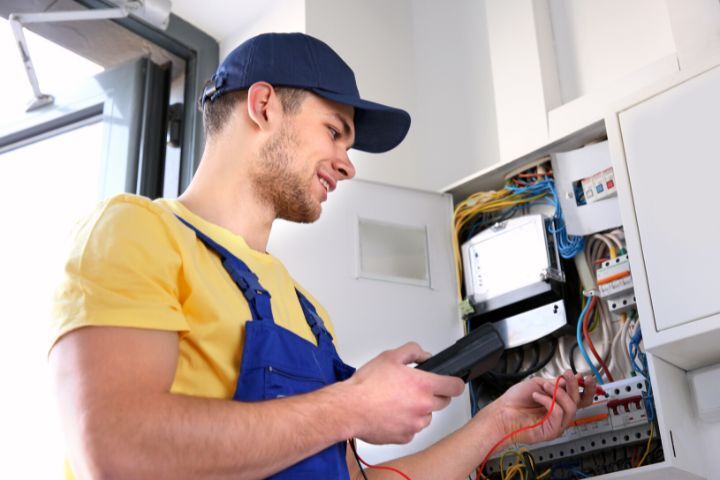 Electrician Measuring Voltage in Distribution Board